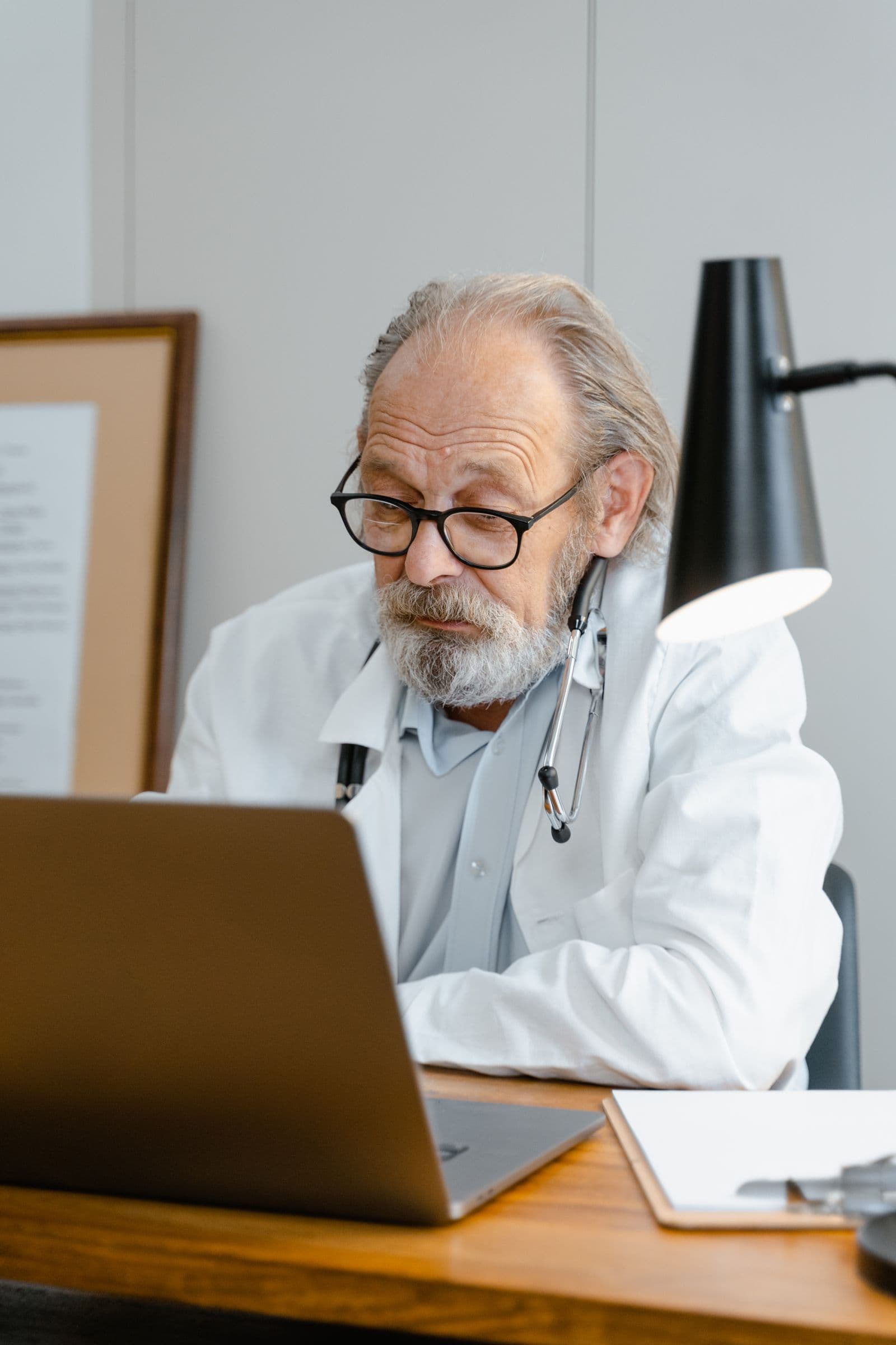 A doctor reviewing patient records on a laptop